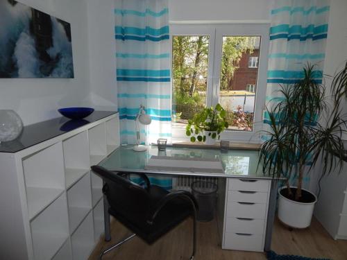 einen Schreibtisch mit Stuhl in einem Zimmer mit Fenster in der Unterkunft Neues modern möbliertes Komfortappartement in Hilchenbach