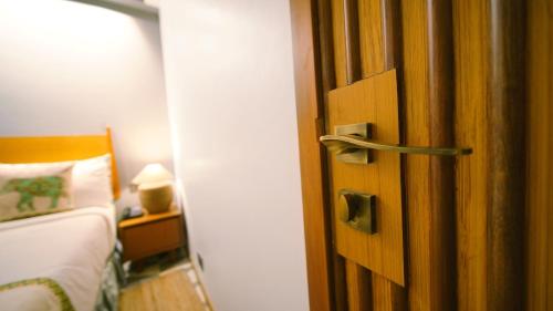 a door to a bedroom with a bed and a lamp at Hotel Nova Boutique in Rajkot