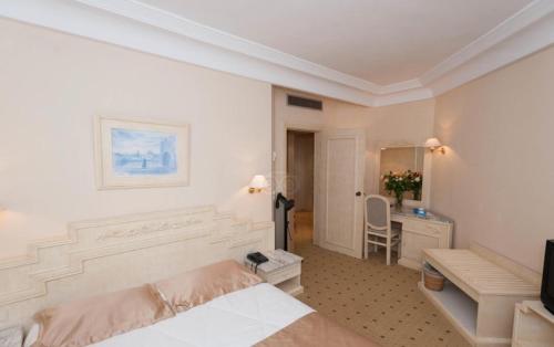 スースにあるL'Orient Palace Resort and Spaのベッドと机があるホテルの部屋
