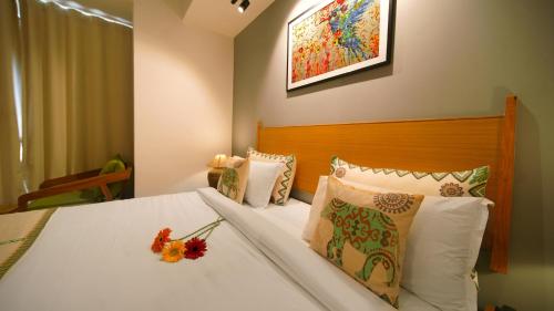 a bedroom with a bed with white sheets and pillows at Hotel Nova Boutique in Rajkot