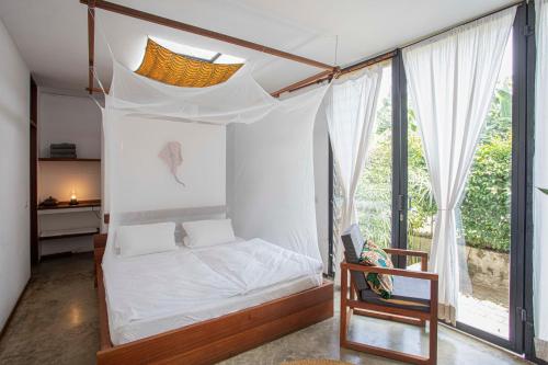 a bedroom with a bed and a large window at Kaliwa Lodge in Moshi