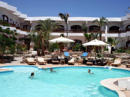 a pool at a hotel with people in it at Planet Oasis Resort Dahab in Dahab