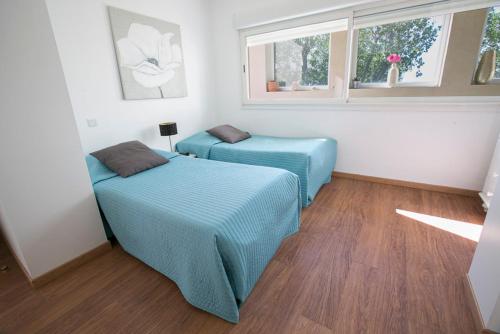 a bedroom with two beds and a window at Les Terrasses Du Grand Large Bord de Mer in Palavas-les-Flots