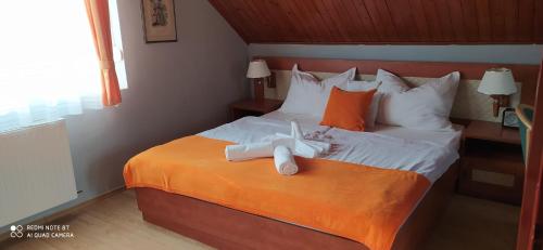 Una habitación de hotel con una cama con toallas. en Hermina Panzió, en Siófok