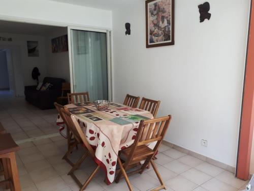 a dining room table with chairs and a table cloth at Résidence Azuréa in Le Gosier