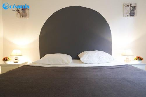a bedroom with a large bed with two pillows at Résidence Azuréa in Le Gosier