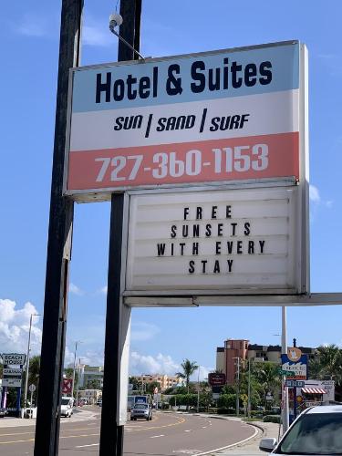 a sign for a hotel and suites on a street at The Beach House - Treasure Island in St Pete Beach