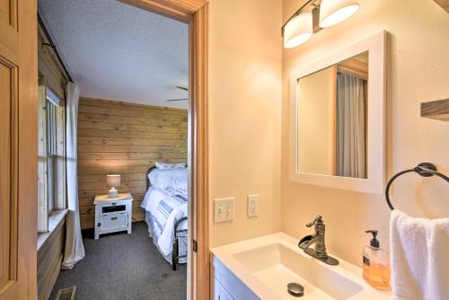 a bathroom with a sink and a bedroom with a bed at Lakefront Waterloo Cabin with Dock, Kayaks and Grill! in Waterloo