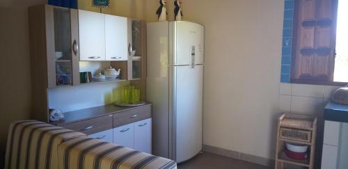 a kitchen with a white refrigerator and white cabinets at Casa na Praia com Piscina in Costa Dourada