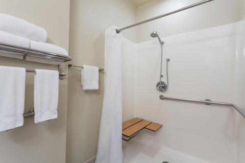 a bathroom with a shower with white towels at Holiday Inn Express Harvey-Marrero, an IHG Hotel in Harvey