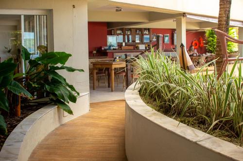 a house with a porch with plants and a dining room at Juquehy La Plage Hotel in Juquei