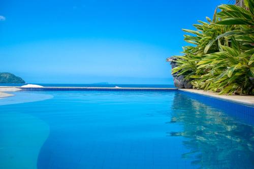 a swimming pool with the ocean in the background at Juquehy La Plage Hotel in Juquei