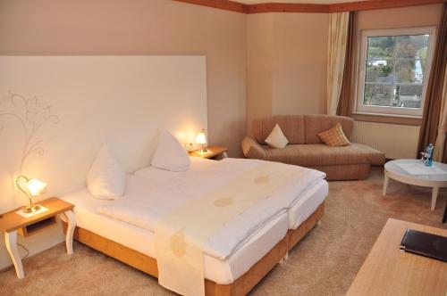 a hotel room with a large bed and a couch at Hotel Sauerländer Hof in Hallenberg