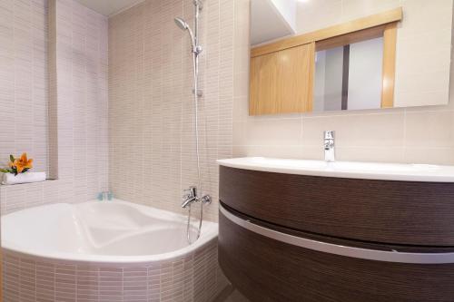 a bathroom with a tub and a sink at Hotel Acta Laumon in Barcelona