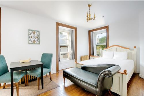 een slaapkamer met een bed, een bureau en een stoel bij Le Haute Ville in Québec
