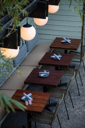 a row of wooden tables and chairs on a patio at The Pearl Hotel in San Diego