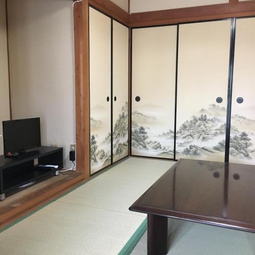 sala de estar con mesa y TV en Villa Hineno / Vacation STAY 79056 en Izumi-Sano
