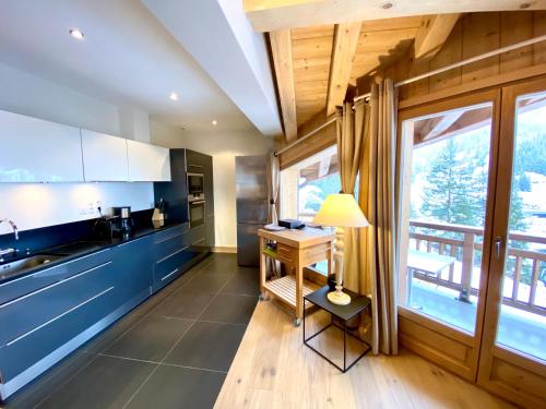 a kitchen with blue cabinets and a table with a lamp at les craterelles in Courchevel