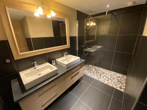 a bathroom with two sinks and a mirror at les craterelles in Courchevel