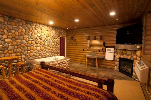 1 dormitorio con chimenea, 1 cama y bañera en Destinations Inn Theme Rooms, en Idaho Falls