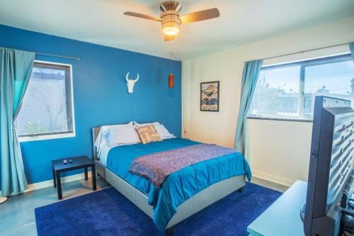 a blue bedroom with a bed and a ceiling fan at The Downtown Vintage Gem in Las Vegas