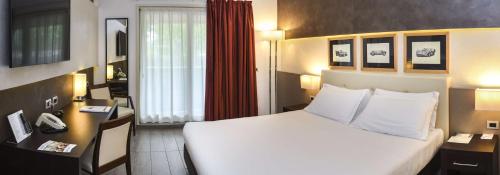 a hotel room with a large bed and a desk at Best Western Plus Hotel Modena Resort in Formigine