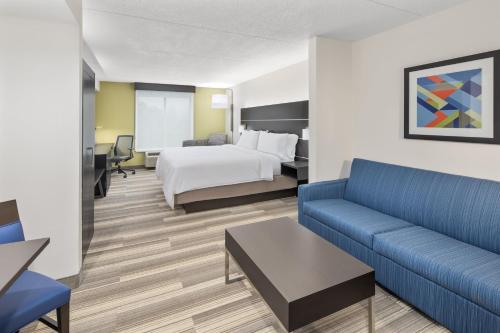 a hotel room with a bed and a couch at Holiday Inn Express & Suites Greenville-I-85 & Woodruff Rd by IHG in Greenville