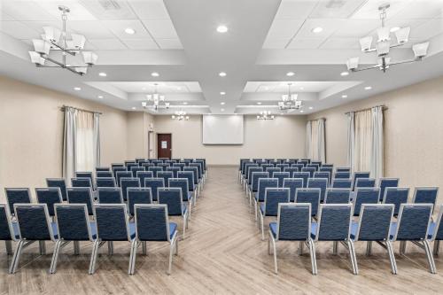 an empty room with blue chairs and a screen at Holiday Inn Express & Suites Greenville-I-85 & Woodruff Rd by IHG in Greenville