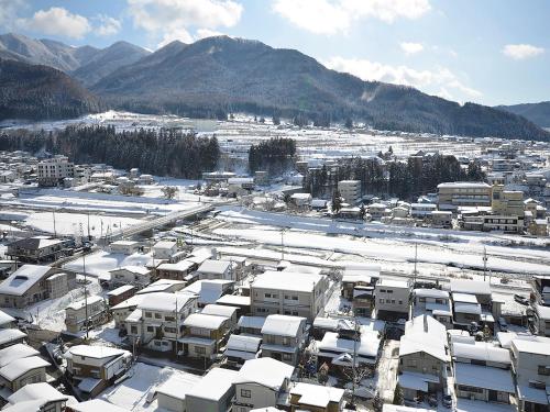 a city covered in snow with mountains in the background at Ryokan Biyunoyado in Yamanouchi