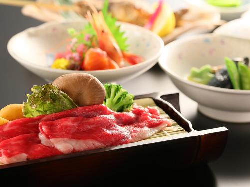 a plate of food on a table with bowls of food at Ryokan Biyunoyado in Yamanouchi