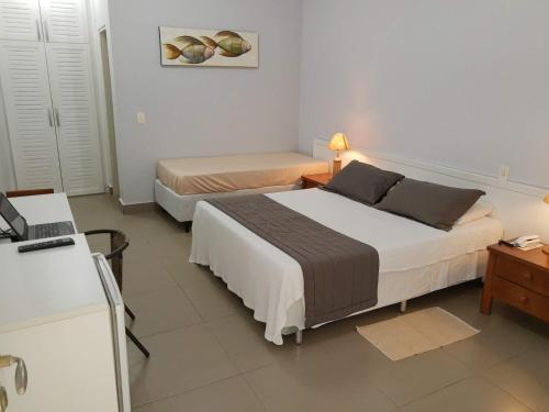 En eller flere senge i et værelse på Flat com serviços na Riviera