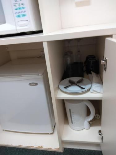 a cupboard with a coffee maker and a toilet at Inverell Motel in Inverell