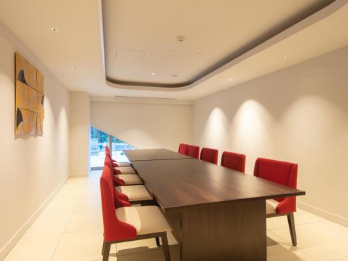 a conference room with a long table and red chairs at Miyakojima Kurima Resort Seawood Hotel in Miyako Island