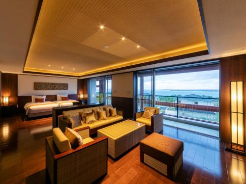 a hotel room with a bed and a living room at Miyakojima Kurima Resort Seawood Hotel in Miyako Island