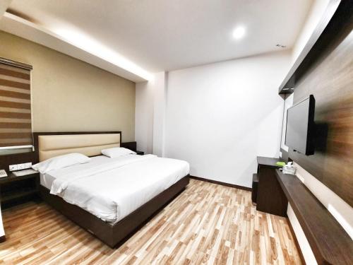 a bedroom with a bed and a flat screen tv at Namii Hotel in Nagoya