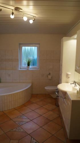 a bathroom with a tub and a sink and a window at Harz-Chill Wernigerode in Wernigerode
