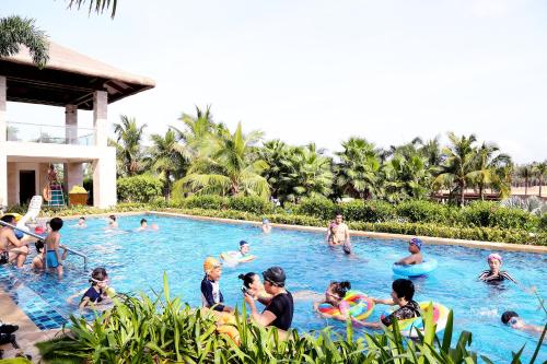 a group of people in a pool at a resort at The Mangrovetree Sanya Resort in Sanya