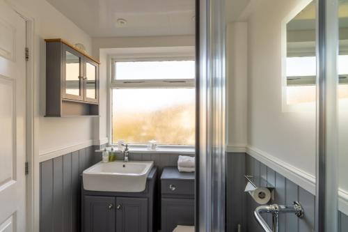 a bathroom with a sink and a window at Holly Lodge Guest House with FREE off site health club in Windermere