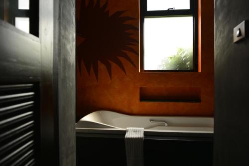 a bathroom with a bath tub and a window at Chaweng Noi Pool Villa in Chaweng Noi Beach