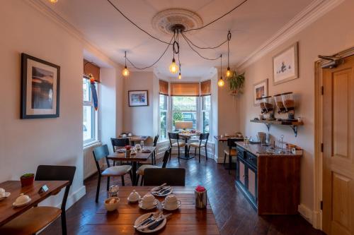 um restaurante com mesas e cadeiras num quarto em Holly Lodge Guest House with FREE off site health club em Windermere