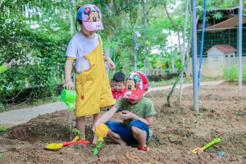 two young children playing in a sandbox at The Mangrovetree Sanya Resort in Sanya