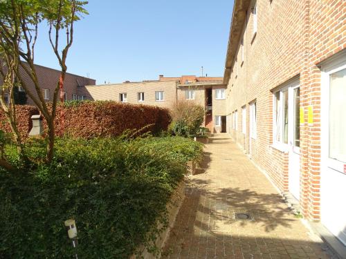 an alley with a brick building and a tree at Budget Flats Leuven in Leuven