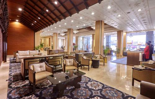 a lobby with chairs and tables in a building at The Everest Hotel in Kathmandu