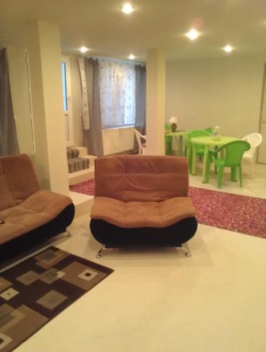 a living room with two chairs and a green table at Comfort Plus in Tbilisi City