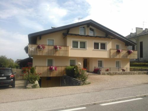 a house with flowers on the balconies on a street at Casa Pallanch in Fai della Paganella