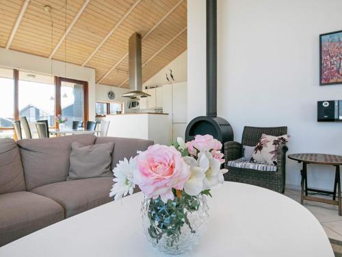 een vaas met roze bloemen op een tafel in een woonkamer bij 8 person holiday home in Ulfborg in Thorsminde