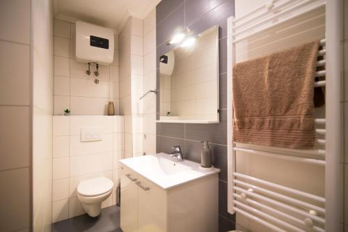 La petite salle de bains est pourvue d'un lavabo et de toilettes. dans l'établissement Apartment SunDelight, à Split