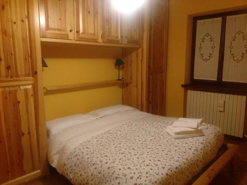 a bedroom with a bed with two towels on it at Casa Grande in Pragelato