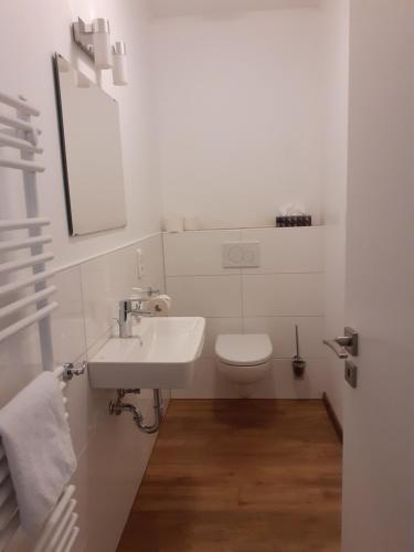 uma casa de banho branca com um WC e um lavatório em Ferienwohnung Angelika em Wilhelmshaven