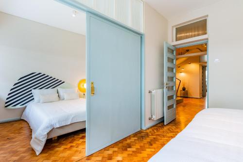 a bedroom with two beds and a sliding glass door at UNIQUE Modernist Duplex apartment & PARKING in Porto